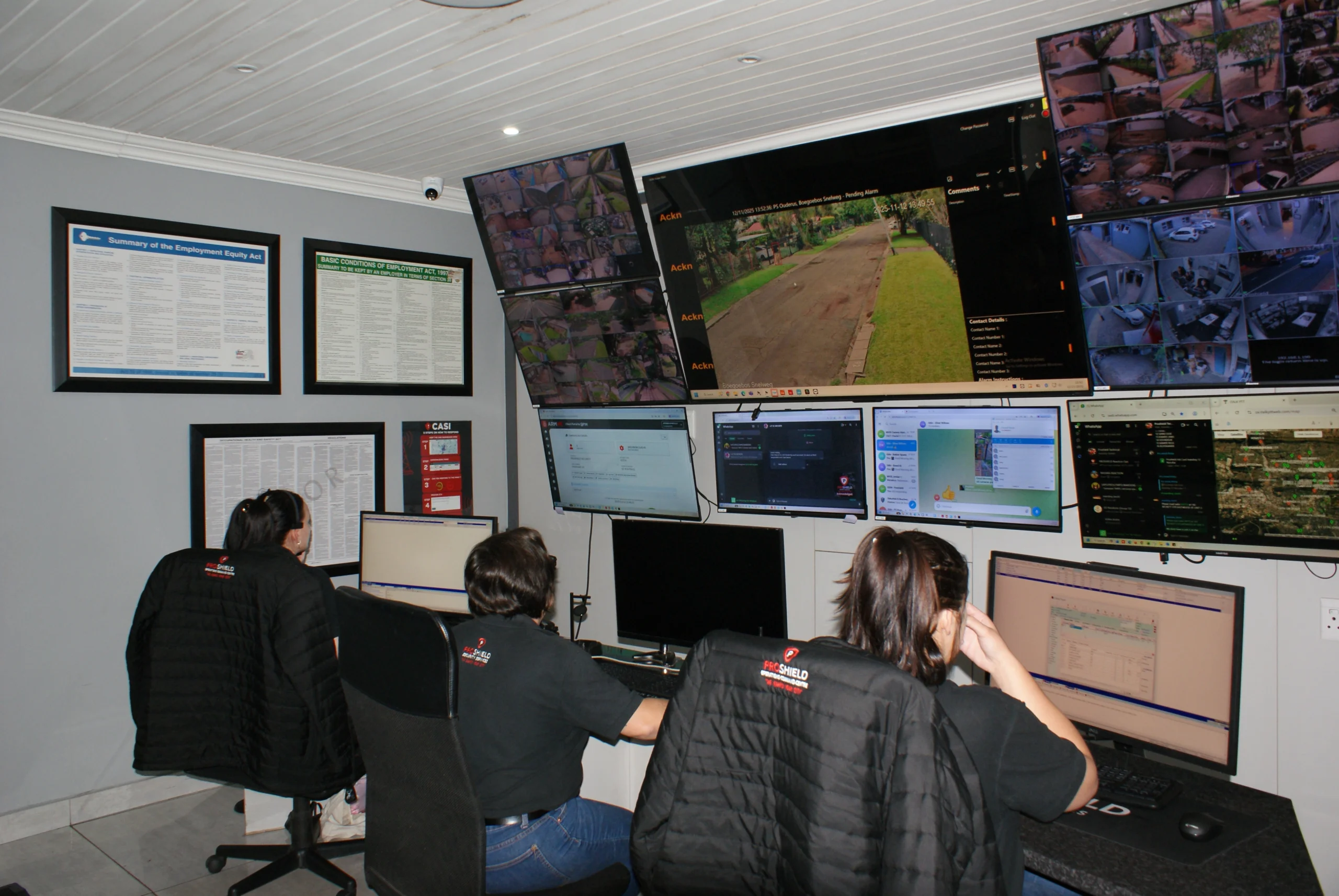 Proshield electronic security team sitting inside a control room monitoring security camera screens.